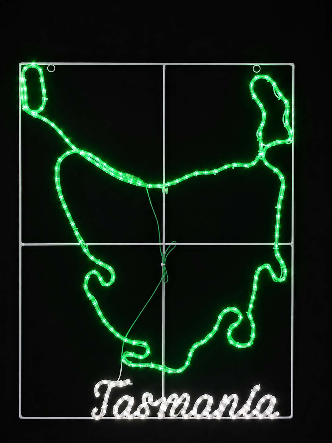 A Christmas motif  depicting the outline of Tasmania, with bright green illuminated path lines, a white grid background, and the word "Tasmania" in white script at the bottom, shown against a black background.