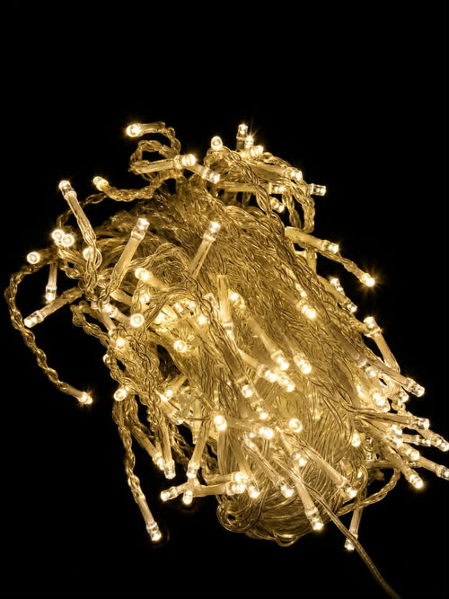 Neon Noel - bundle of 3x2m warm white LED curtain string lights glowing against a solid black background.